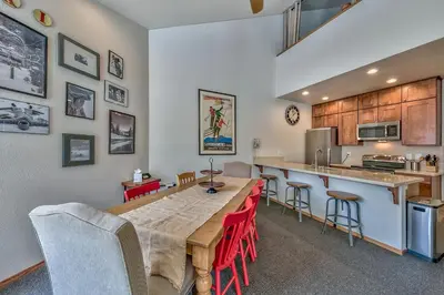 a kitchen with a long table and red chairs at 3302 Sun Meadows in Kirkwood