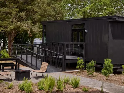 a black tiny house with a bench and a table at AutoCamp Yosemite in Midpines