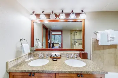 a bathroom with two sinks and a large mirror at Resort at Squaw Creek 808 in Olympic Valley