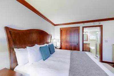 a bedroom with a large white bed with blue pillows at Resort at Squaw Creek 808 in Olympic Valley