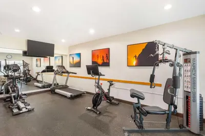a gym with several exercise bikes and a flat screen tv at Best Western Plus Villa Del Lago Inn Patterson in Patterson