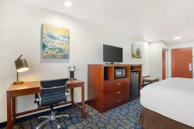 a hotel room with a bed and a desk with a computer at Best Western Plus Villa Del Lago Inn Patterson in Patterson