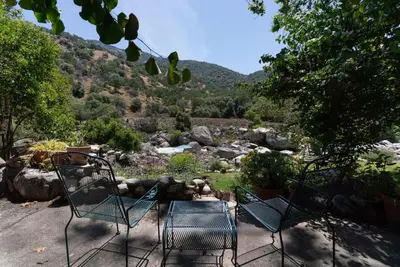 two chairs and a table with a view of a mountain at Buckeye Tree Lodge in Three Rivers