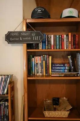 a book shelf with many books on it at Buckeye Tree Lodge in Three Rivers