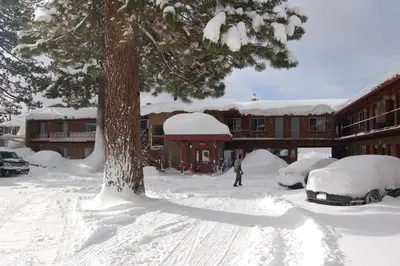 a person standing in a parking lot covered in snow at Crown Motel in Kings Beach