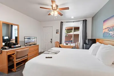 a bedroom with a bed and a desk and a television at Crown Motel in Kings Beach