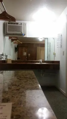 a bathroom with a counter with a sink and a fan at The Gold Lodge in Sonora