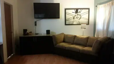 a living room with a couch and a flat screen tv at The Gold Lodge in Sonora