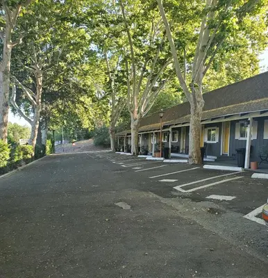 an empty parking lot next to a building with trees at The Gold Lodge in Sonora