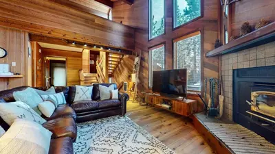 a living room with a leather couch and a fireplace at Tennis Village 14 Townhouse in Mammoth Lakes