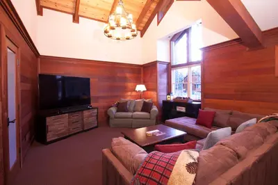 a living room with a couch and a flat screen tv at Luxury Lodgepole Home at Northstar in Truckee