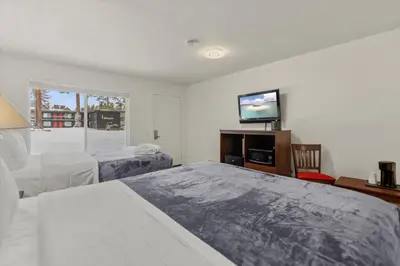 a bedroom with two beds and a flat screen tv at Ambassador Lake Tahoe in South Lake Tahoe