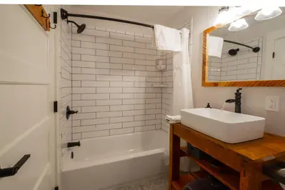 a bathroom with a sink and a tub and a mirror at Eastside Guesthouse and Bivy in Bishop