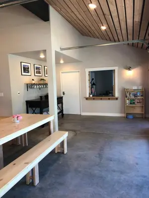 a room with two wooden benches and a television at Eastside Guesthouse and Bivy in Bishop