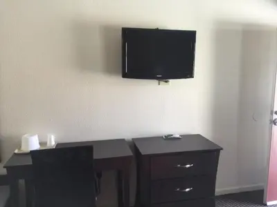 a room with a desk and a flat screen tv on the wall at Portal Motel in Lone Pine