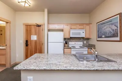 a kitchen with a sink and a white refrigerator at Sunstone 326 in Mammoth Lakes
