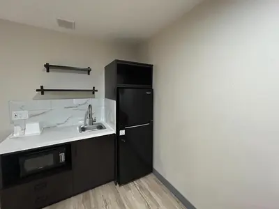 a kitchen with a black refrigerator and a sink at Studio 6 Suites Cameron Park, CA Folsom in Cameron Park