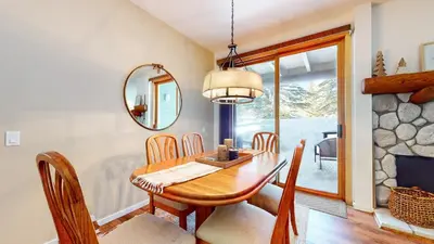 a dining room with a table and chairs and a mirror at Snowcreek 887 Condo in Mammoth Lakes