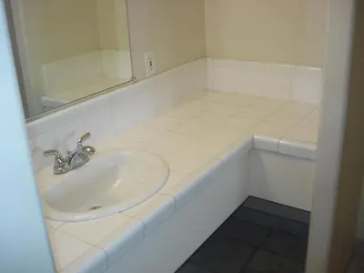 a white bathroom with a sink and a mirror at Garlic Farm Inn in Gilroy