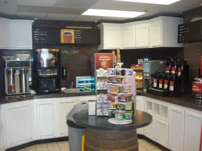 a kitchen with a counter with a table with a refrigerator at Garlic Farm Inn in Gilroy