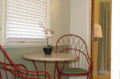 a table with two chairs and a table with a plant on it at El Rancho Motel in Bishop