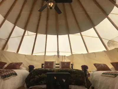 a yurt with two beds and a ceiling fan at Olancha RV Park and Motel in Olancha