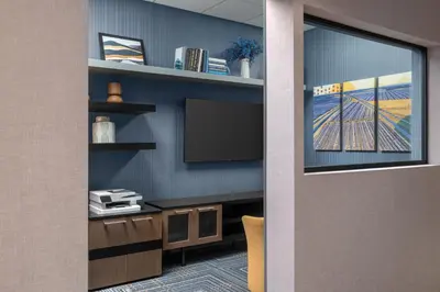 a room with a tv on a wall with a desk at Homewood Suites by Hilton Fresno in Fresno