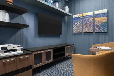 a living room with a television and a chair at Homewood Suites by Hilton Fresno in Fresno