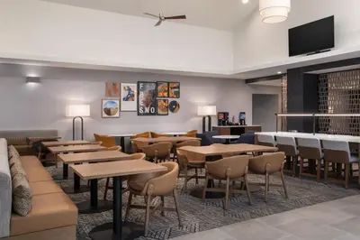 a restaurant with tables and chairs and a flat screen tv at Homewood Suites by Hilton Fresno in Fresno