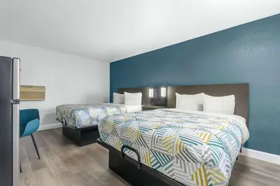 a hotel room with two beds and a blue wall at Studio 6 Suites Madera, CA Yosemite in Madera