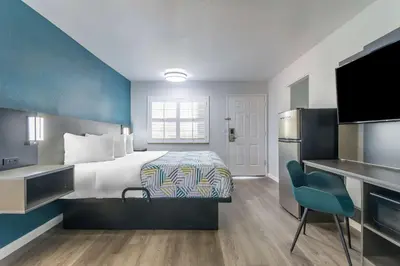 a hotel room with a bed and a flat screen tv at Studio 6 Suites Madera, CA Yosemite in Madera