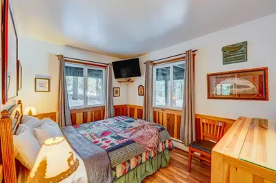 a bedroom with a bed and two windows at Peaceful Forest Retreat in Carnelian Bay