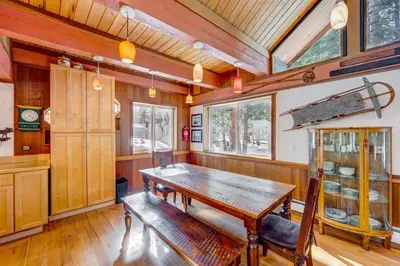 a dining room with a wooden table and a bench at Peaceful Forest Retreat in Carnelian Bay
