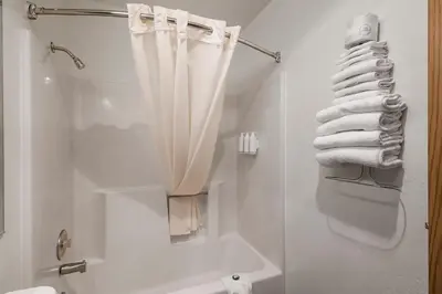 a bathroom with a shower and a toilet and towels at Sonora Aladdin Motor Inn in Sonora