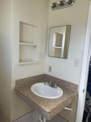 a bathroom with a sink and a mirror at Holiday Motel Oakdale in Oakdale