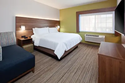 a hotel room with a large bed and a window at Holiday Inn Express & Suites - Tulare by IHG in Tulare
