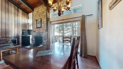 a dining room with a table and a fireplace at Chamonix Condo 94 Condo in Mammoth Lakes