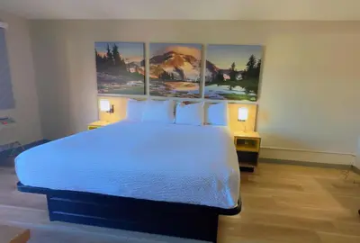 a bedroom with a large bed with three paintings on the wall at Days Inn by Wyndham Reno in Reno