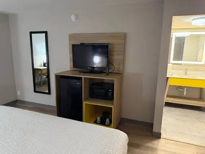 a room with a tv on a stand with a bed at Days Inn by Wyndham Reno in Reno