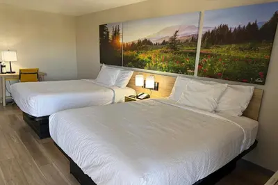 two beds in a hotel room with paintings on the wall at Days Inn by Wyndham Reno in Reno