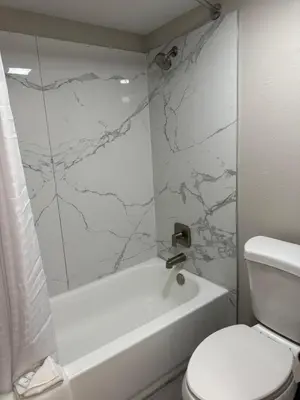 a bathroom with a white tub and a toilet at Days Inn by Wyndham Reno in Reno