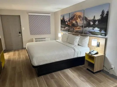 a hotel room with a large bed and a table at Days Inn by Wyndham Reno in Reno