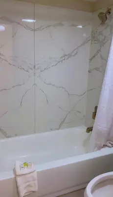 a white bathroom with a tub and a toilet at Days Inn by Wyndham Reno in Reno