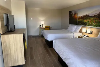 a hotel room with two beds and a flat screen tv at Days Inn by Wyndham Reno in Reno