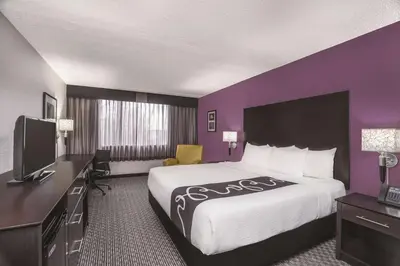 a hotel room with a large bed and a tv at La Quinta Inn by Wyndham Fresno Yosemite in Fresno
