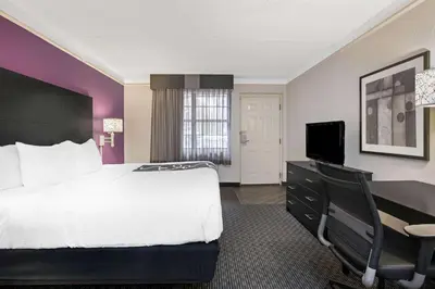 a hotel room with a large bed and a desk at La Quinta Inn by Wyndham Fresno Yosemite in Fresno
