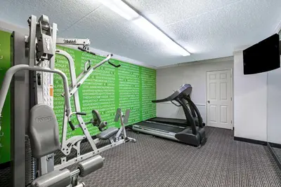 a gym with a treadmill and a green wall at La Quinta Inn by Wyndham Fresno Yosemite in Fresno