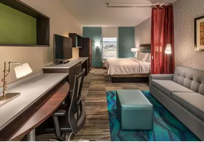 a hotel room with a bed and a couch at Home2 Suites By Hilton Reno in Reno