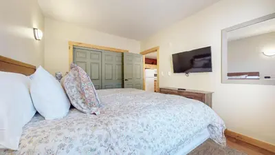 a bedroom with a bed with pillows and a television at Sunstone #126 Condo in Mammoth Lakes