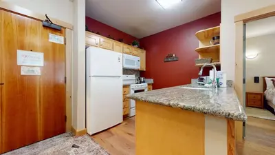 a kitchen with red walls and a white refrigerator at Sunstone #126 Condo in Mammoth Lakes
